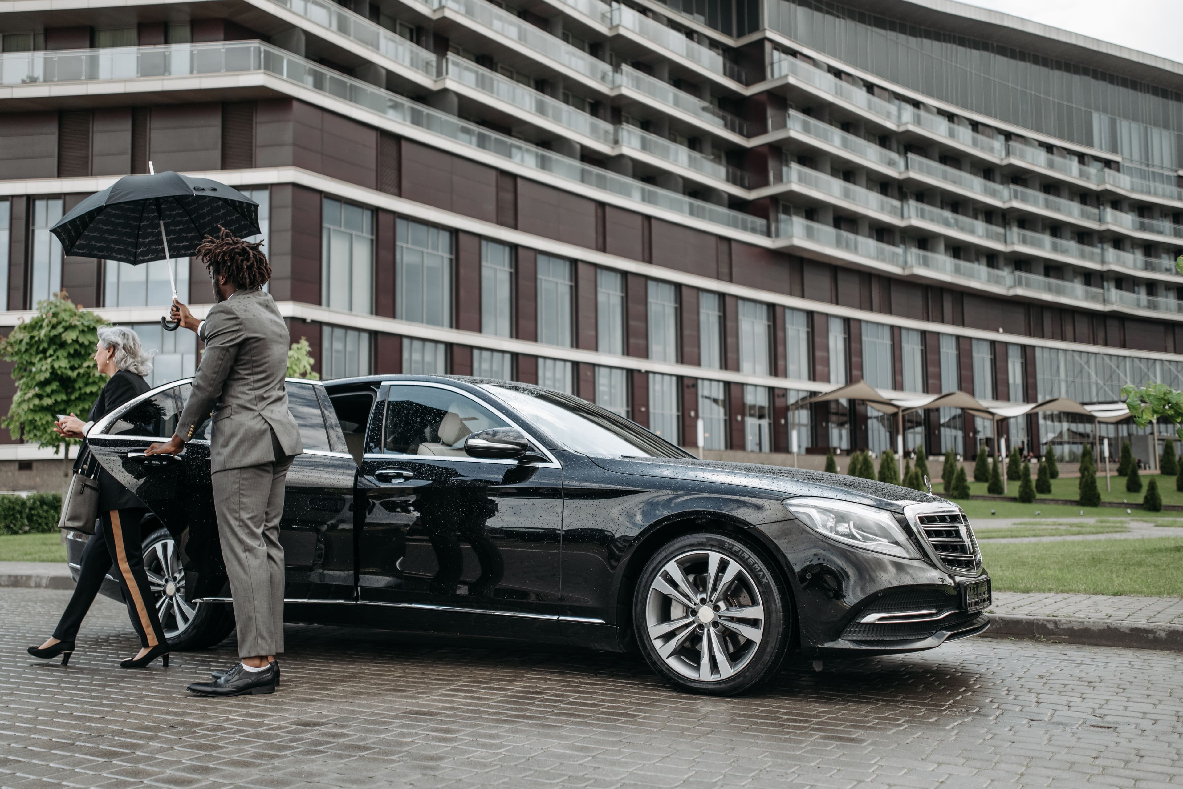 Chauffeur assisting clients at airport pickup